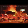 photograph of L.A. City firefighters at a fire in a two story building.